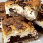 Decadent Chocolate Chip Cheesecake Bars with layers of buttery crust, creamy cheesecake, rich chocolate ganache, and a golden cookie topping.