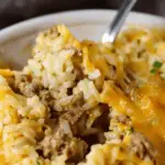 A delicious serving of lovely Cheddar-Crusted Ground Beef and Rice Casserole, featuring tender beef, fluffy rice, and golden, melted cheddar cheese.