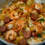 A vibrant skillet of Spicy Fried Cabbage with tender shrimp and sliced smoked sausage, ready to serve.