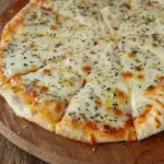 Sliced cheesy garlic tortilla bread topped with melted mozzarella and herbs on a wooden serving board.