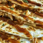 Close-up of grilled cheesy BBQ chicken quesadillas, filled with shredded chicken and drizzled with barbecue sauce.