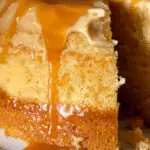 Close-up of a moist sweet potato pound cake with caramel glaze dripping down the sides and pooling at the base.